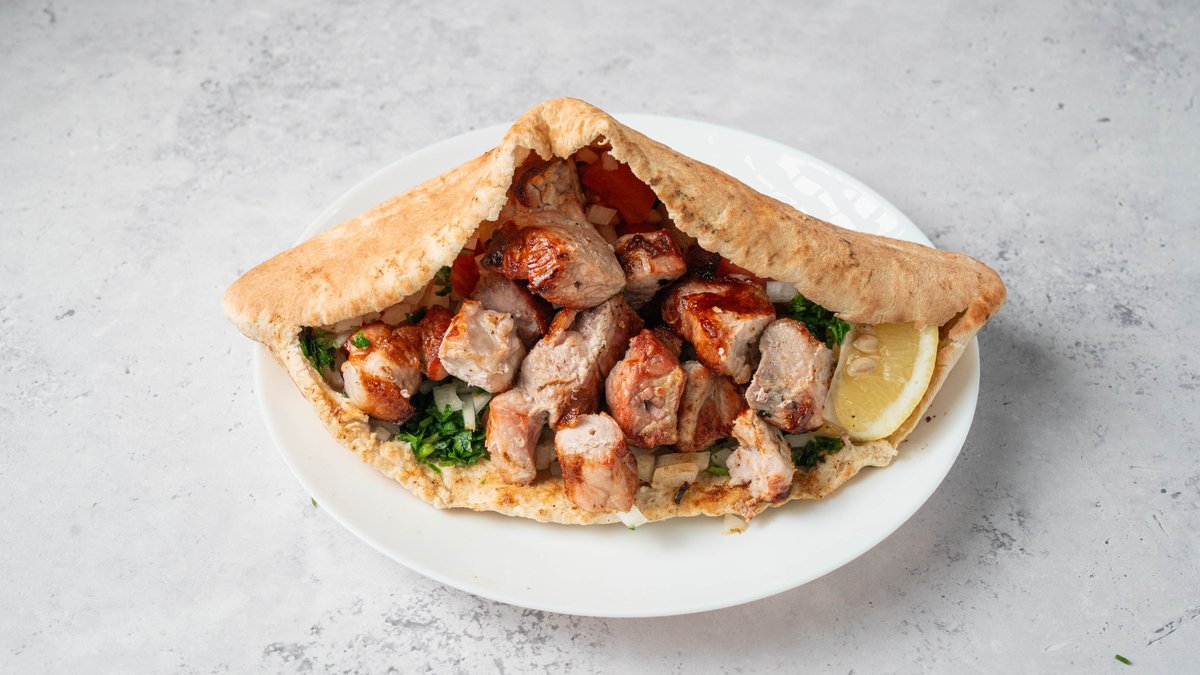 Cypriot souvlaki and sheftalia wrapped in warm pita bread with fresh salad and tzatziki